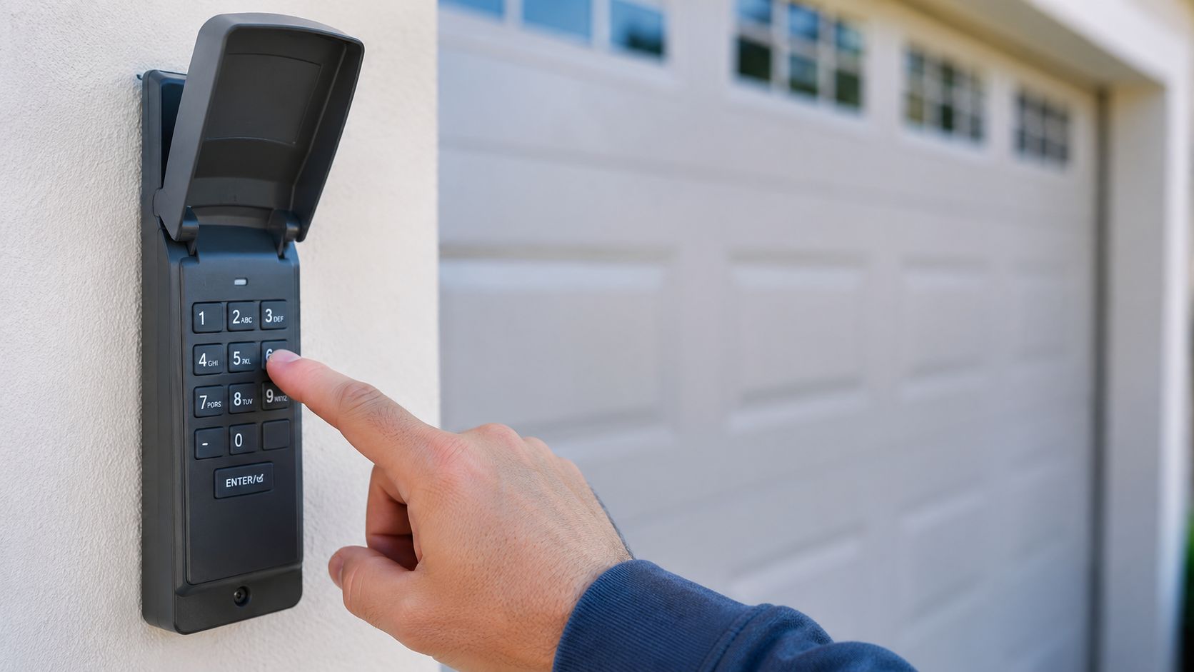 A close-up view of a person pressing buttons on a garage door keypad mounted on a wall.